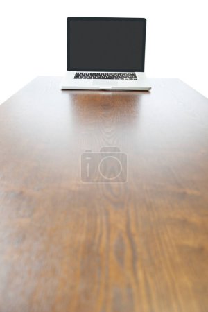 Téléchargez les photos : Ordinateur portable à l'extrémité de la table en bois - en image libre de droit