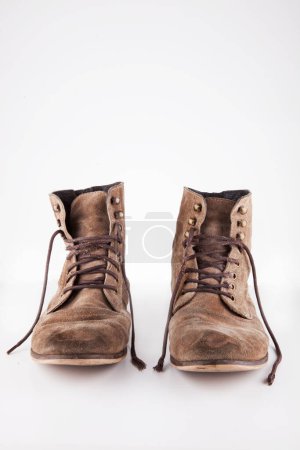 Téléchargez les photos : Paire de bottes brunes avec lacets détachés sur fond blanc - en image libre de droit