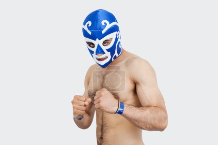 Foto de Retrato de un joven luchador masculino sin camisa con máscara de lucha libre sobre fondo gris - Imagen libre de derechos