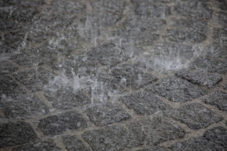 Téléchargez les photos : Jet d'eau fort battant bruyamment sur la chaussée et pulvérisé - en image libre de droit