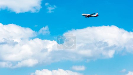 Foto de Avión establece tierra entre nubes cúmulos - Imagen libre de derechos