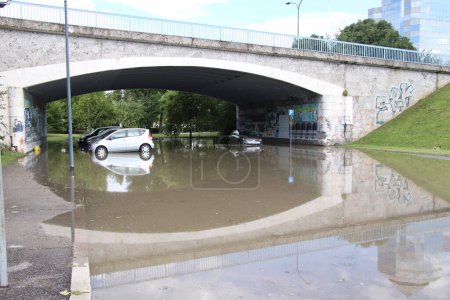Téléchargez les photos : Voitures inondées dans le parking sous le pont dans la ville - en image libre de droit