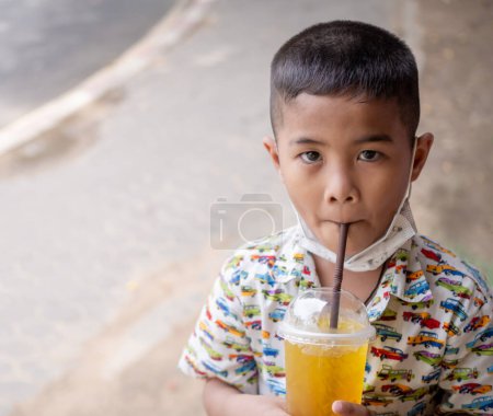 Photo for Boy sucking water from a glass of water - Royalty Free Image