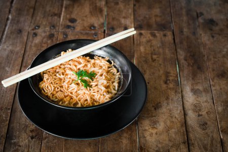 Photo for "Instant noodles in a cup on the wooden floor" - Royalty Free Image