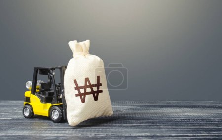 Photo for Forklift transports a south korean won money bag. Attraction of investments in business and economy, cheap loans, leasing. Borrowing on capital market. Stimulating economy. Crisis recovery measures. - Royalty Free Image