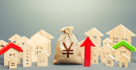 Photo for Yen Yuan money bag and a city of house figures and red up arrow. Recovery and growth in property prices, high demand. Increase in rent. Investments. Increase in revenues to municipal budget. - Royalty Free Image