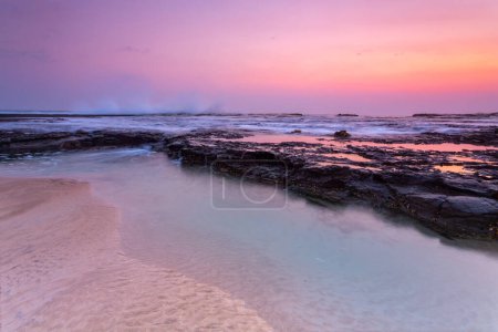 Photo for Pretty sunrise over the beach and rock shelf with reflections - Royalty Free Image