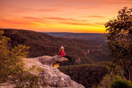 Téléchargez les photos : Randonneur assis sur le bord du précipice rocheux avec vue sur la vallée de l'escarpement - en image libre de droit