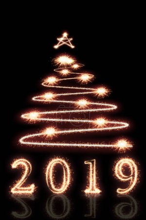 Foto de 2019 y árbol de Navidad escrito con fuegos artificiales Sparkle en negro - Imagen libre de derechos