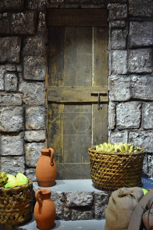 Photo for Claypot water jar and basket of fruits outside the doorstep - Royalty Free Image