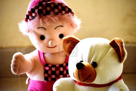 Foto de Juguete osito de peluche con juguete de muñeca en el fondo, de cerca - Imagen libre de derechos