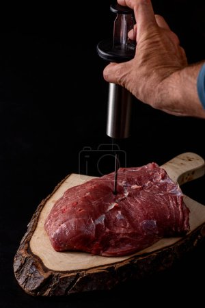 Photo for Man preparing beef carcass on a black background. - Royalty Free Image
