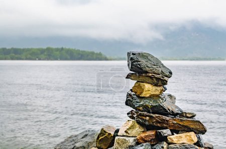 Téléchargez les photos : Pierres posées sous la forme d'une pyramide se trouvent sur le rivage du lac - en image libre de droit