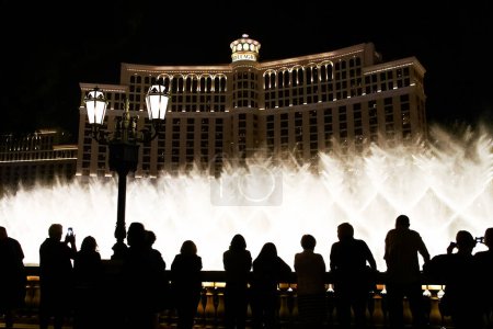 Téléchargez les photos : Scène nocturne avec des silhouettes de personnes admirant le spectacle des fontaines Bellagio à Las Vegas - en image libre de droit