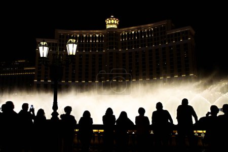 Téléchargez les photos : Scène nocturne avec des silhouettes de personnes admirant le spectacle des fontaines Bellagio à Las Vegas - en image libre de droit