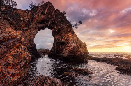 Téléchargez les photos : Lever de soleil matinal à la grotte d'arche de mer dramatique - en image libre de droit