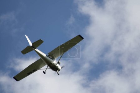 Ein Kampfjet fliegt durch einen wolkenverhangenen blauen Himmel