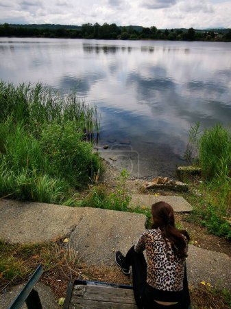 Téléchargez les photos : Une femme debout devant un plan d'eau - en image libre de droit