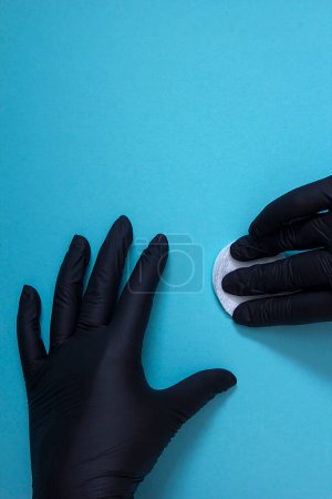 Foto de Manos en guantes de nitrilo negro aislados sobre fondo azul - Imagen libre de derechos