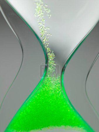 Photo for Hour glass with green grains, time concept - Royalty Free Image