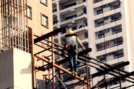 Foto de Trabajador en una obra de construcción con escalera - Imagen libre de derechos