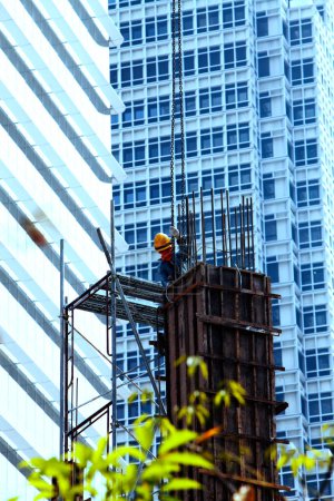 Foto de Hombre en la obra con una grúa y un edificio - Imagen libre de derechos