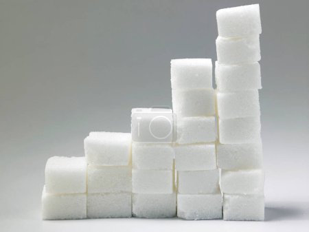 Téléchargez les photos : Empilements ascendants de cubes de sucre concept de risque élevé de sucre dans le sang - en image libre de droit