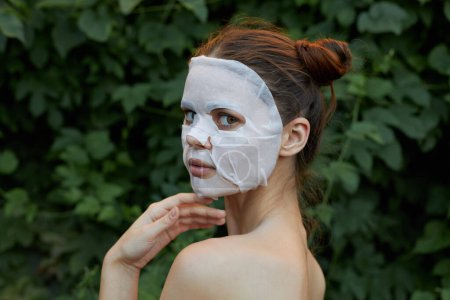 Téléchargez les photos : Belle fille masque cosmétique Nu vue de dos feuilles de peau de sanglier en arrière-plan - en image libre de droit