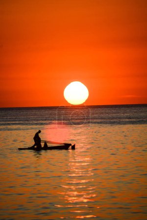 Téléchargez les photos : Pêcheur en bateau au coucher du soleil - en image libre de droit