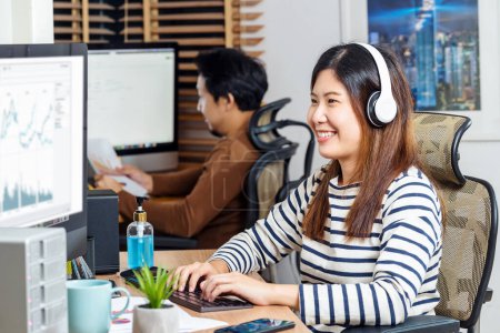 Photo for Couple of Asian colleagues smiling and working at office - Royalty Free Image