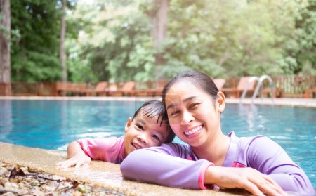 Téléchargez les photos : Joyeux jeune mère et sa fille dans la piscine - en image libre de droit
