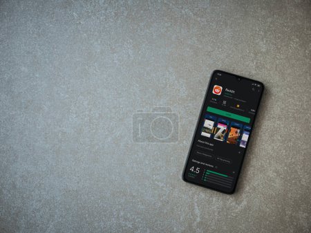 Photo for "Reddit app play store page on the display of a black mobile smar" - Royalty Free Image
