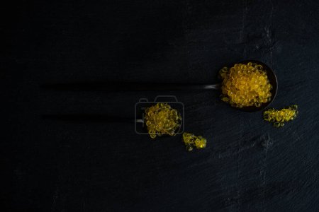 Téléchargez les photos : Caviar de truite jaune sur fond noir - en image libre de droit