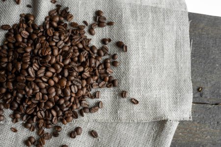 Photo for Brown roasted coffee beans and canva textile, copy space - Royalty Free Image