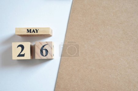 Photo for Wooden calendar on halved white and brown background with date May, 26 - Royalty Free Image