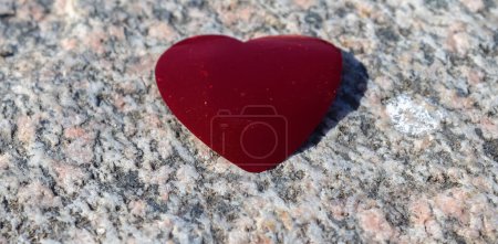 Téléchargez les photos : Romantique coeur d'amour rouge couché sur un fond de granit détaillé - en image libre de droit