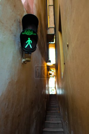 "The architecture of the strago city of Prague. The narrowest street in Europe. The passage between buildings for one person, regulated by traffic lights"