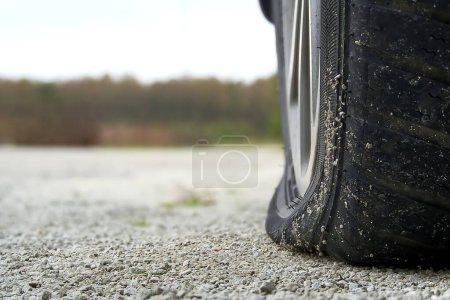 Photo for Close-up of Flat rear tire on car. The right rear broken weel. Damaged rear wheels on parking place. - Royalty Free Image