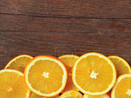 Téléchargez les photos : Fruits orange tranchés sur fond de bois - en image libre de droit