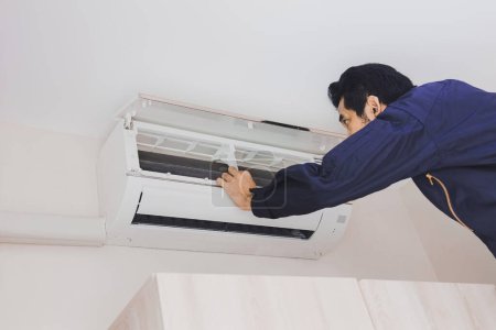 Photo for "Air conditioning repairman in the blue uniform" - Royalty Free Image