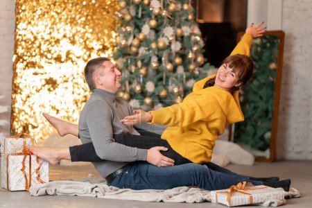 Téléchargez les photos : Un beau couple joyeux accueille les vacances de Noël dans une ambiance chaleureuse - en image libre de droit