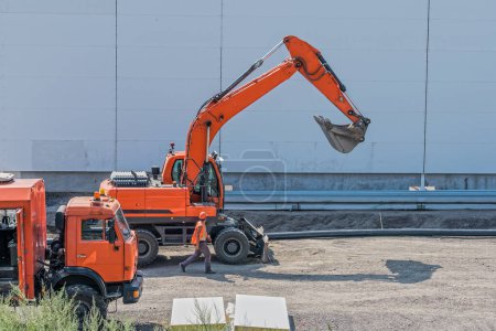 Foto de Capataz y equipo grande, excavadora y camión en el sitio durante la construcción - Imagen libre de derechos