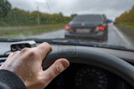 Foto de La mano del conductor en el volante de un coche en un atasco de tráfico debido a las reparaciones de la carretera - Imagen libre de derechos