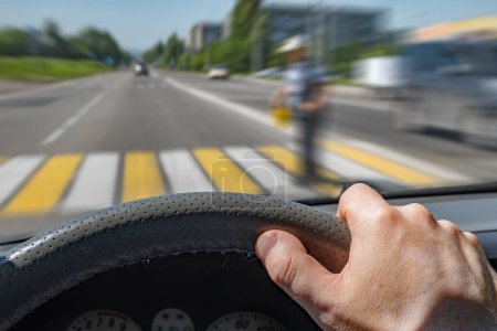 Téléchargez les photos : "la main du conducteur sur le volant d'une voiture se déplaçant à grande vitesse" - en image libre de droit