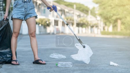 Téléchargez les photos : Femme utilisent des équipements de collecte des ordures gardant les déchets en plastique dans - en image libre de droit