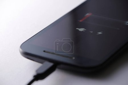 Téléchargez les photos : Smartphone charging battery with micro usb cable - en image libre de droit