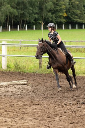Téléchargez les photos : Jockey fille en plein galop équitation ridding prendre un tour - en image libre de droit