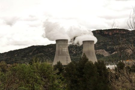 Téléchargez les photos : Cheminées fumeur dans la centrale nucléaire entre les montagnes - en image libre de droit