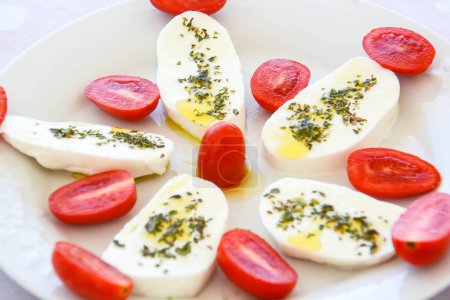 Téléchargez les photos : Mozzarella aux tomates cerises et à l'huile - en image libre de droit