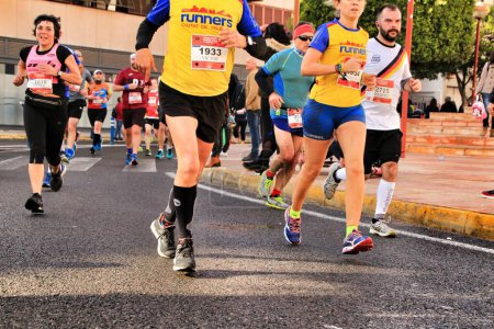 Photo for Santa Pola, Spain- January 20, 2019: Runners in the Half Marathon of the fishing village of Santa Pola, province of Alicante, on a sunny day in January - Royalty Free Image